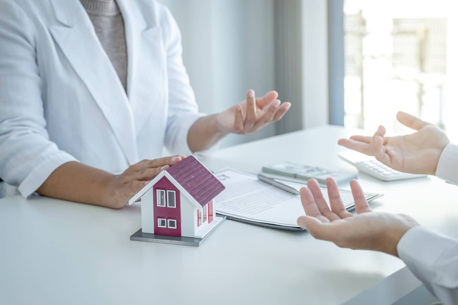 Home model. The real estate agent explains the business contract to the women buyer.