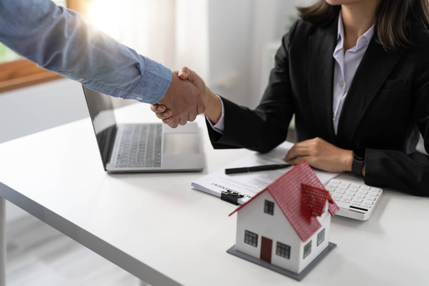 agents and customers shake hands to congratulate on signing a contract