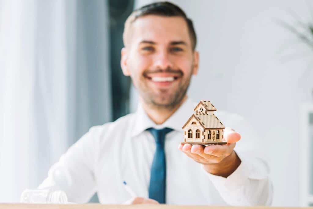 mortgage broker with house model close up